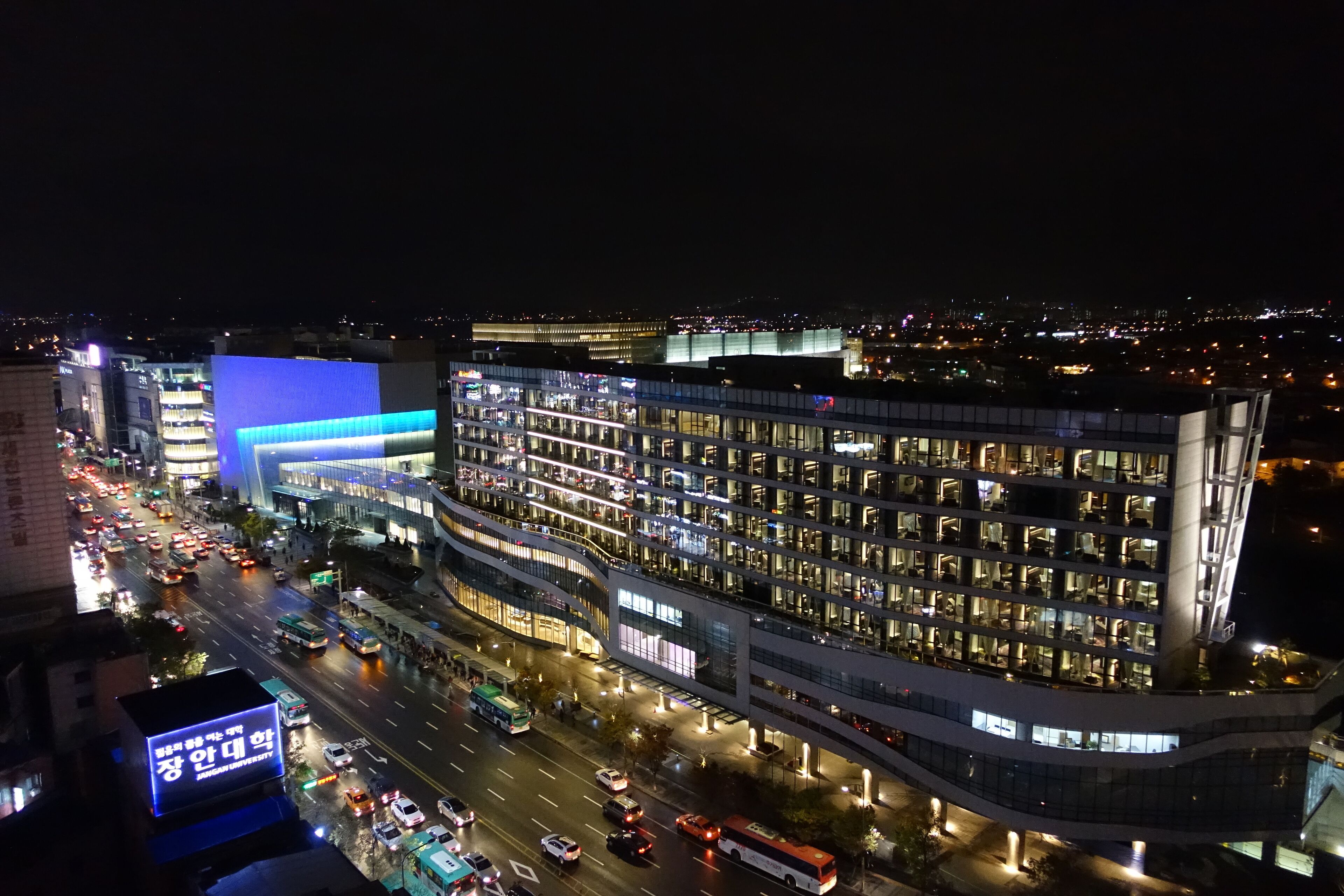 A modern hotel with multiple floors, a prominent glass facade, and a busy street below.