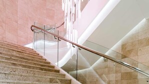 A modern staircase with glass railings and a unique lighting feature. - Novotel Ambassador Suwon (Suwon)