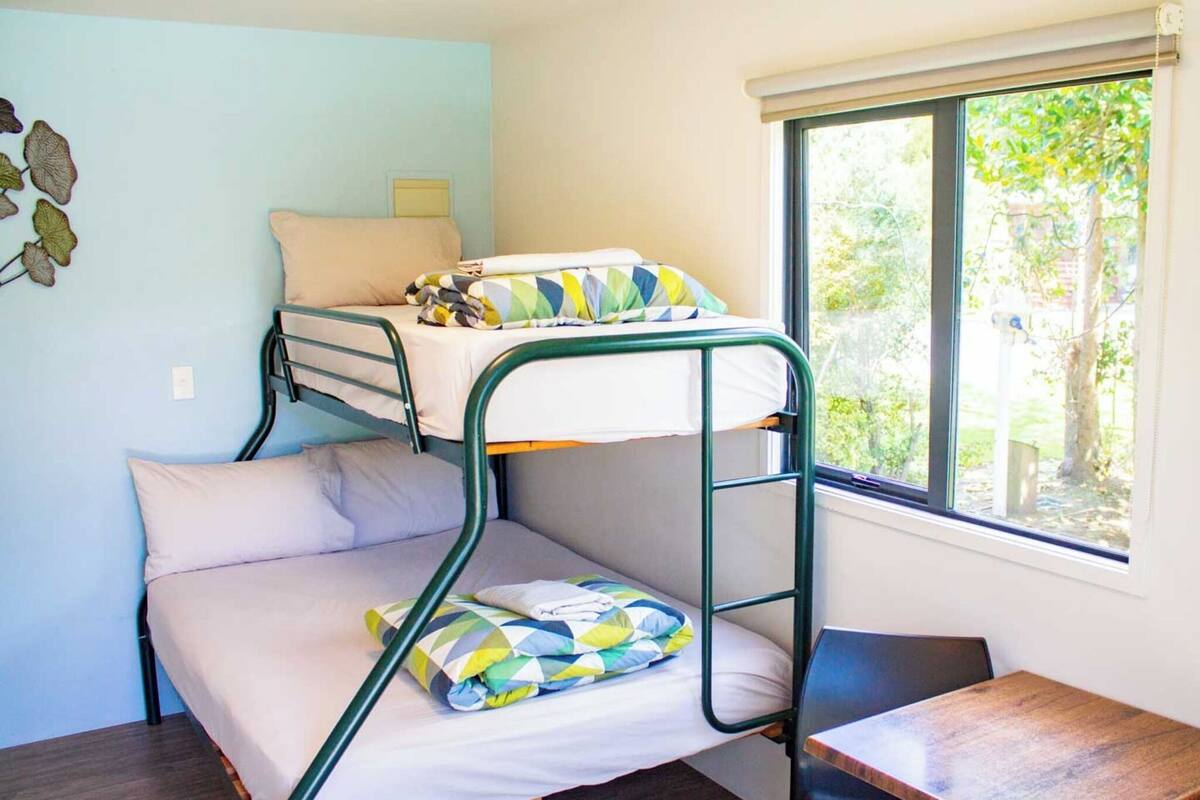 Habitación con literas, una mesita y un adorno en la pared.