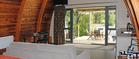 A cozy room with a large bed, a desk, and a view of the outdoors.