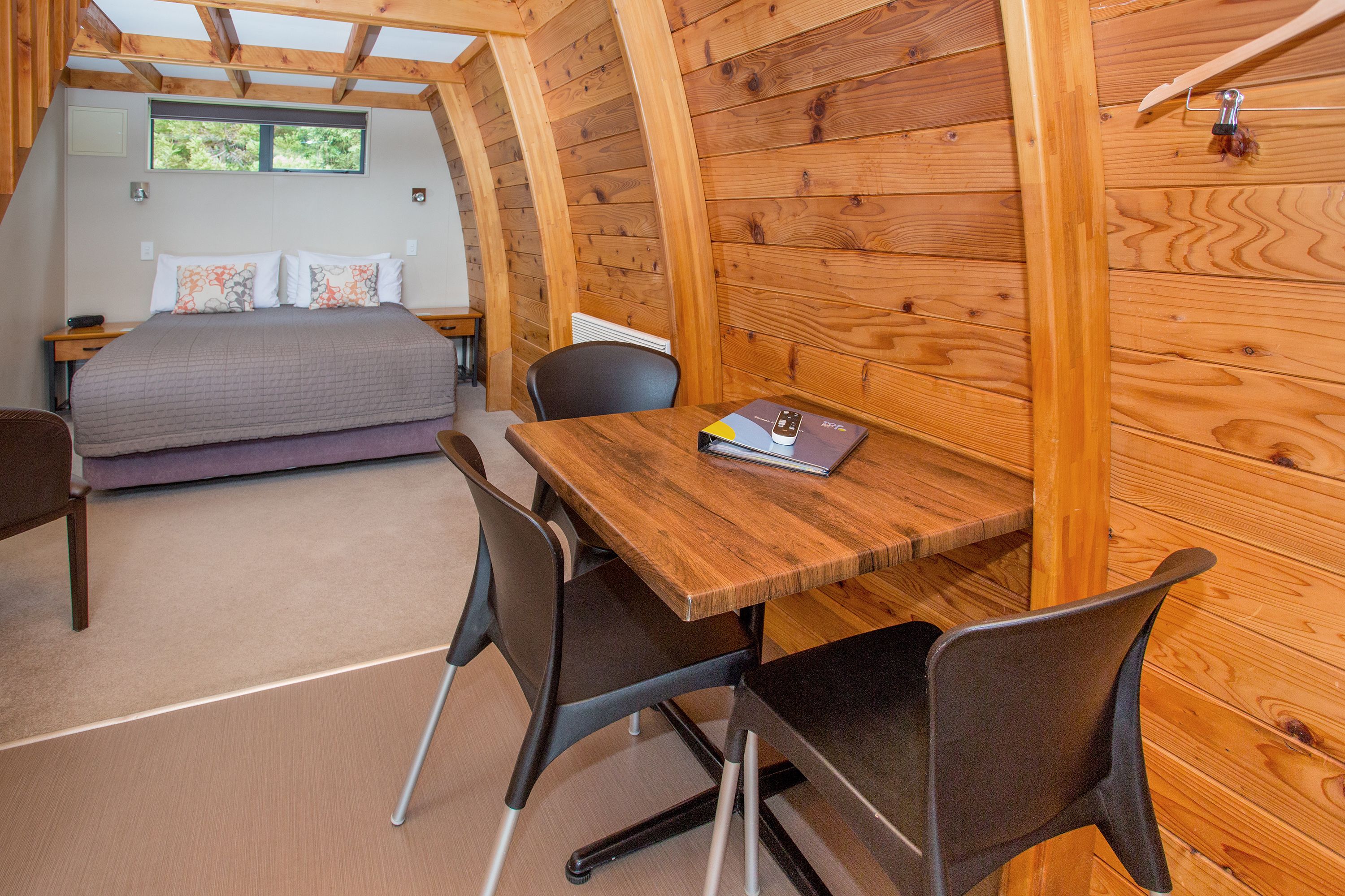 A cozy bedroom with a bed, a desk, and a chair.