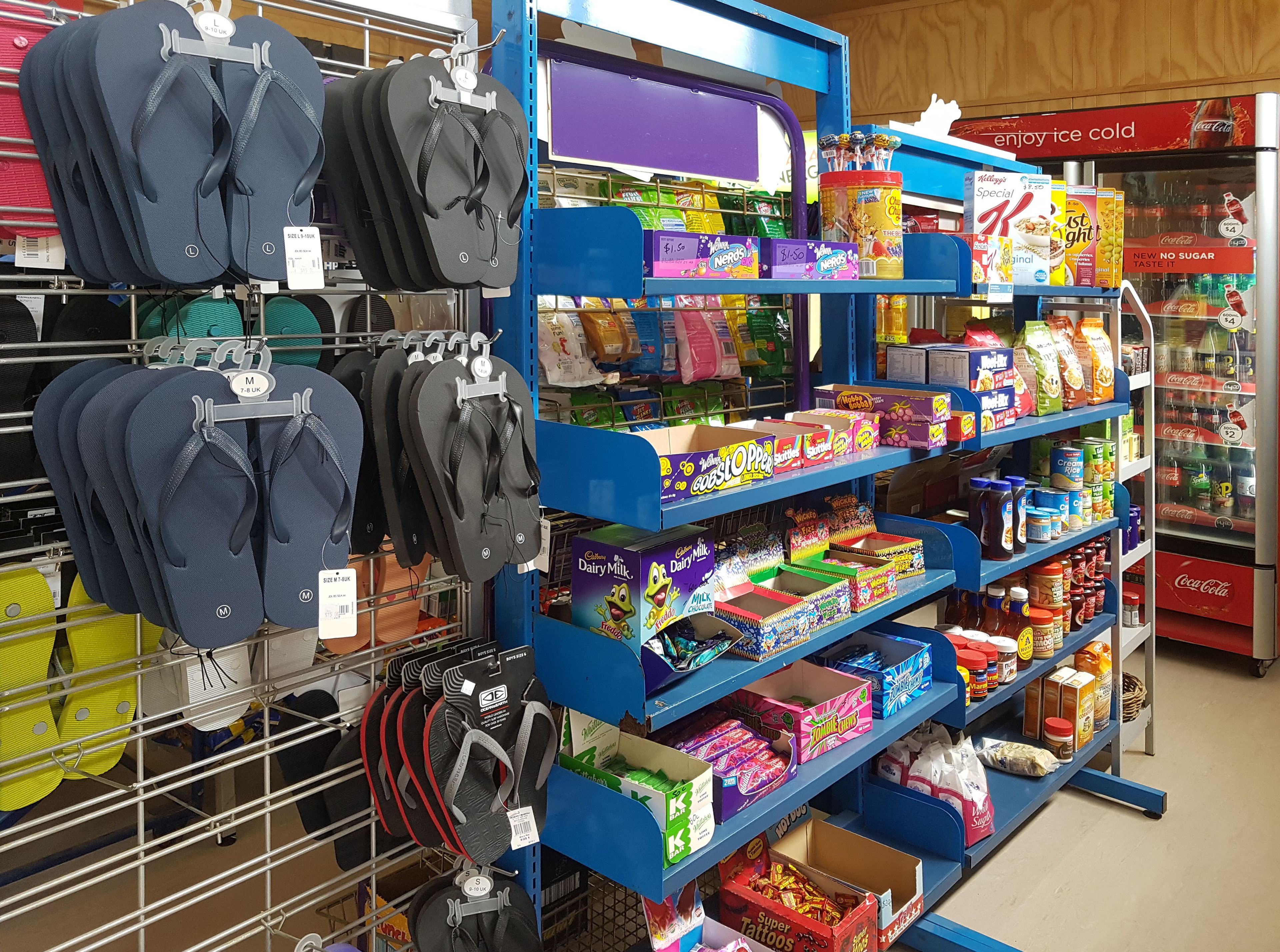 A store aisle with flip-flops, snacks, and beverages.