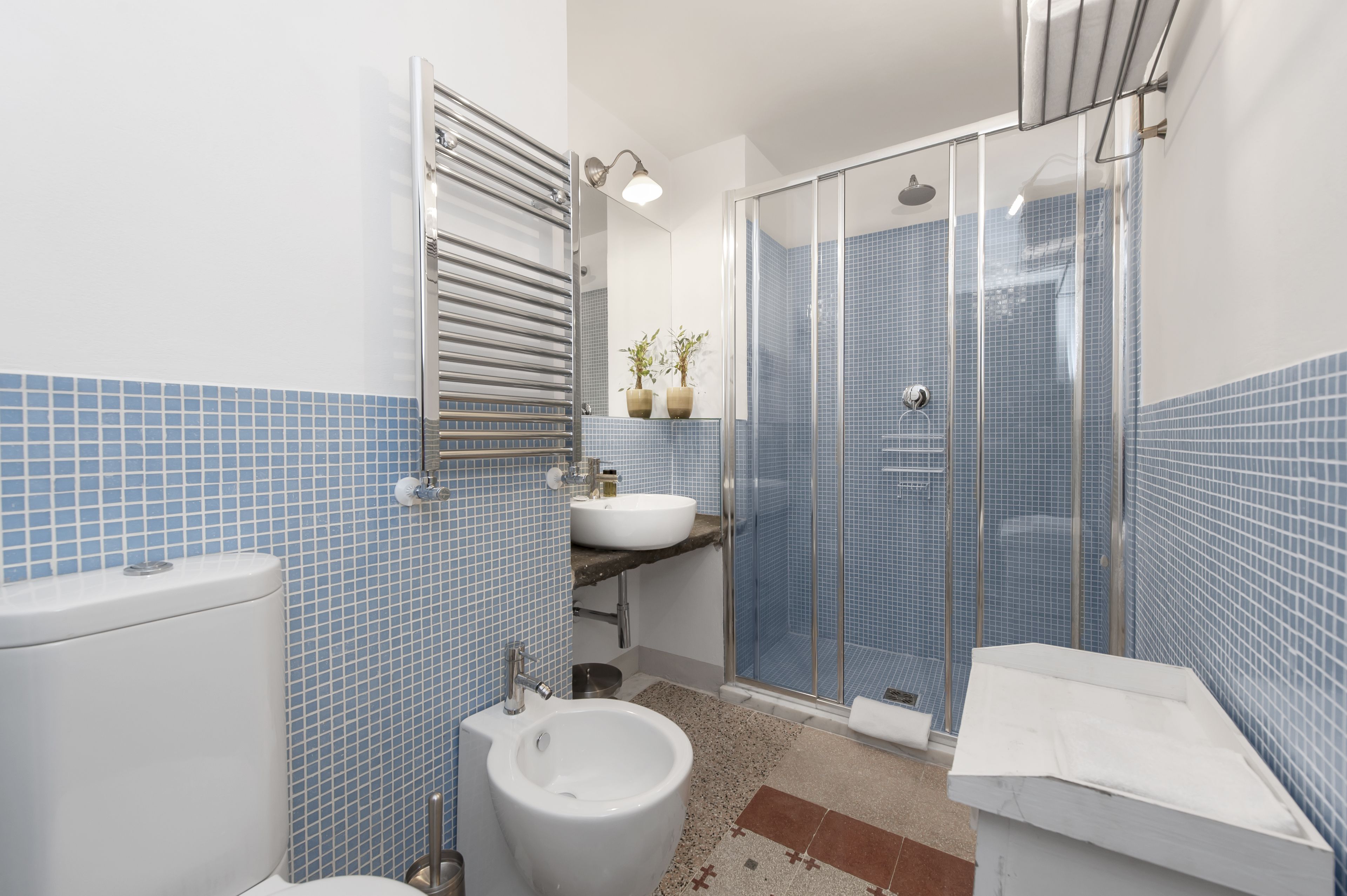 Un bagno con toilette, bidet, lavandino e zona doccia.