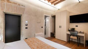 A bedroom with a bed, a desk, a chair, a TV, and a wardrobe.