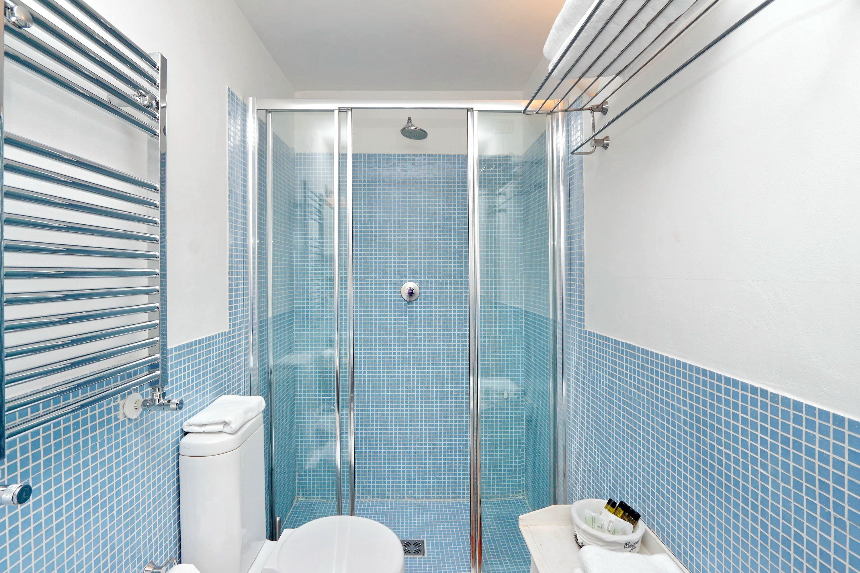 Et badeværelse med brusekabine, toilet og håndvask.
