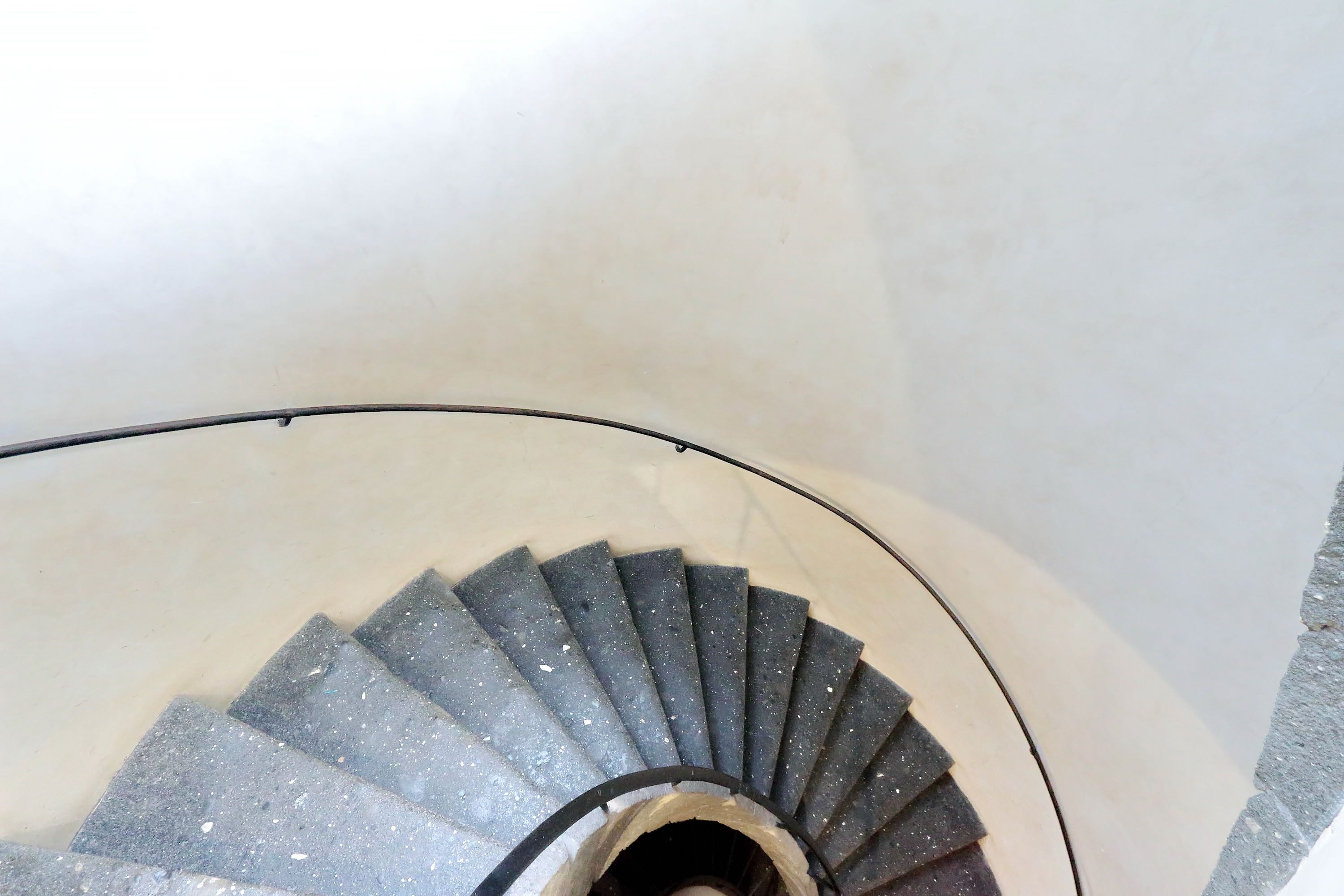 A spiral staircase with a circular handrail and a central void.