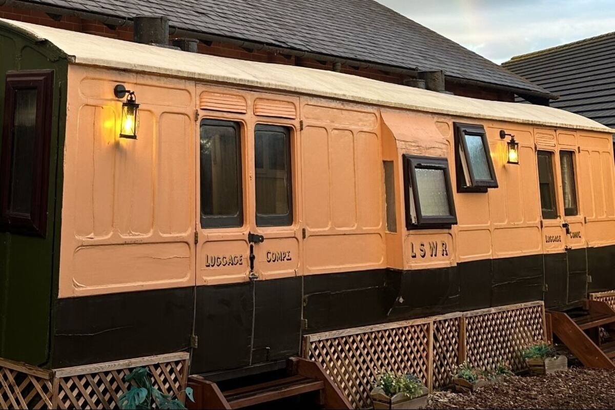 A vintage train carriage with compartments labeled 'LUGGAGE' and 'COMPT'.