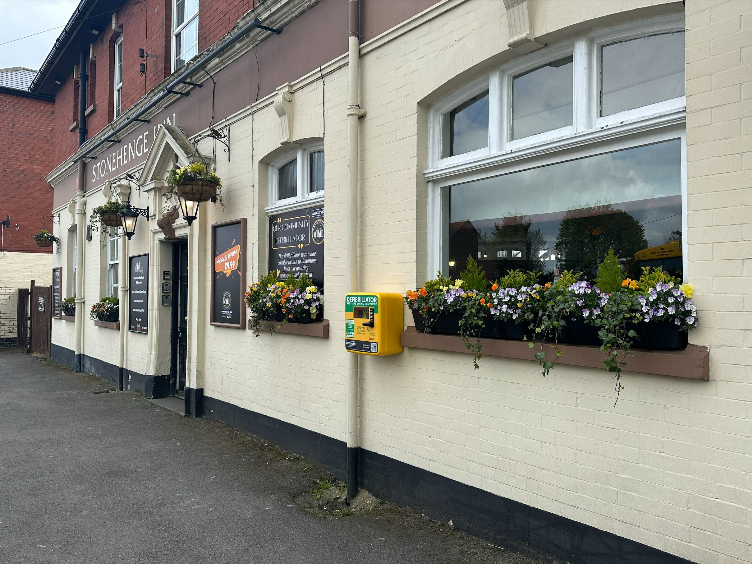 A building with a sign reading "STONEHENGE" and a defibrillator sign.