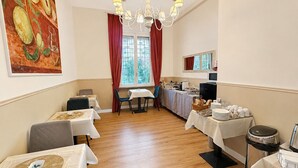 A dining area with tables, chairs, a chandelier, and a painting on the wall. - Roma in una Stanza GuestHouse (Rome)