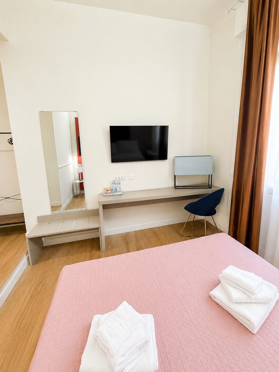 Une chambre d’hôtel avec un lit, une télévision, un bureau et une chaise.