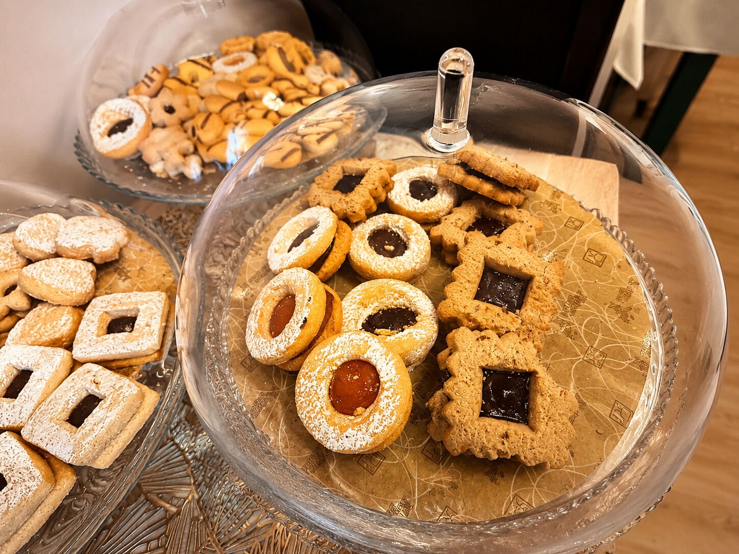 A glass display case with various cookies and pastries.