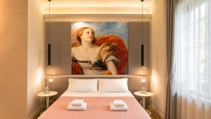 A hotel room with a large bed, two bedside tables, a painting on the wall, and a window with curtains. - Roma in una Stanza GuestHouse (Rome)