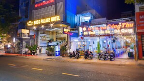 A hotel with a prominent sign for the Boss Palace Hotel, featuring a modern design with a large entrance and a visible staircase. - Boss Palace Hotel (Ho Chi Minh City)