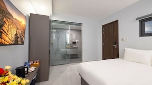 A modern hotel room with a bed, a glass-enclosed shower, a wooden door, and a small window. - Boss Palace Hotel (Ho Chi Minh City)