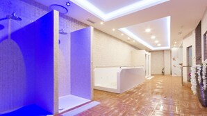 Un baño moderno con ducha, bañera y zona de tocador.