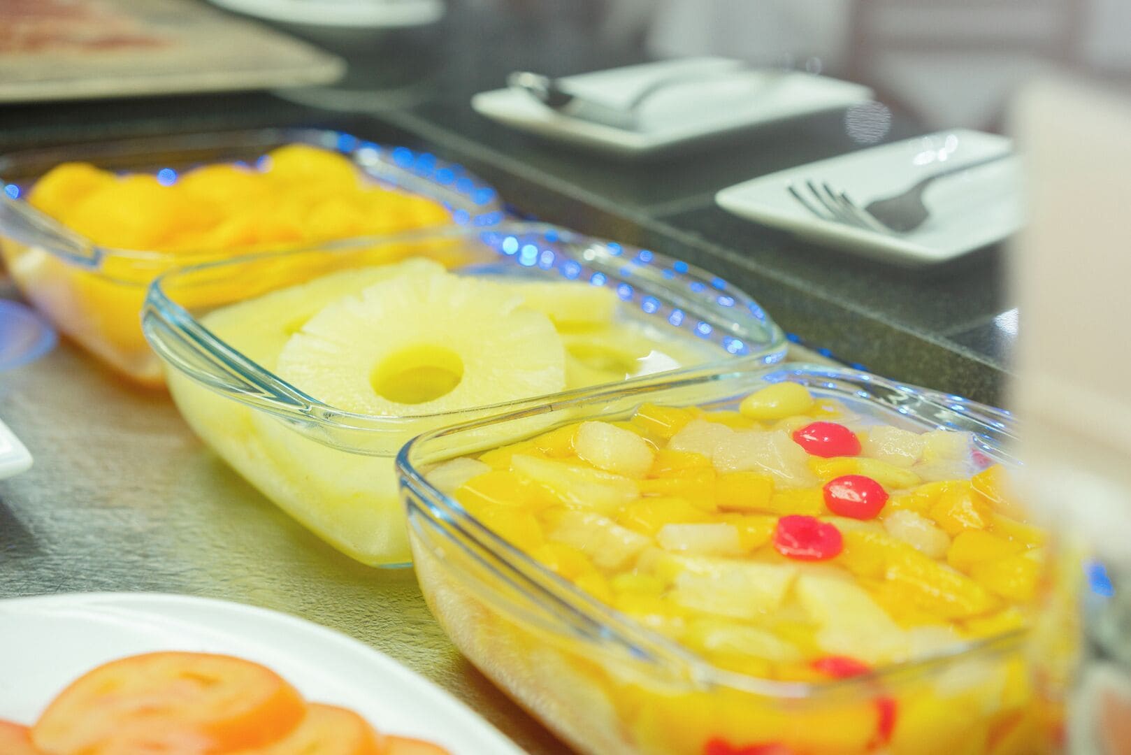 A buffet with various fruit dishes in glass containers.