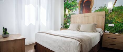 Un dormitorio con una cama grande, cabecera de madera, mesitas de noche y un mural en la pared.