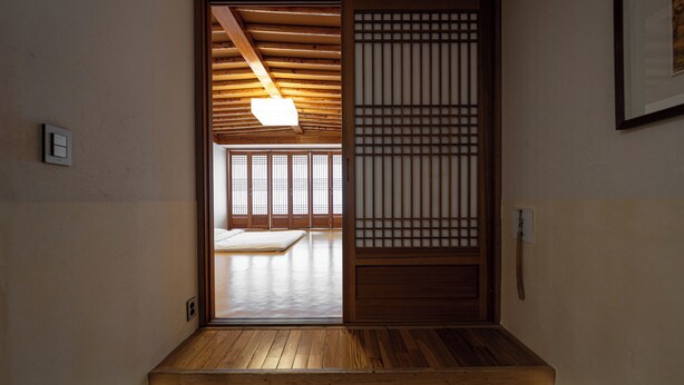 A traditional Japanese room with tatami flooring, a sliding door, and a ceiling with wooden beams. - Eldis Regent Hotel (Daegu)