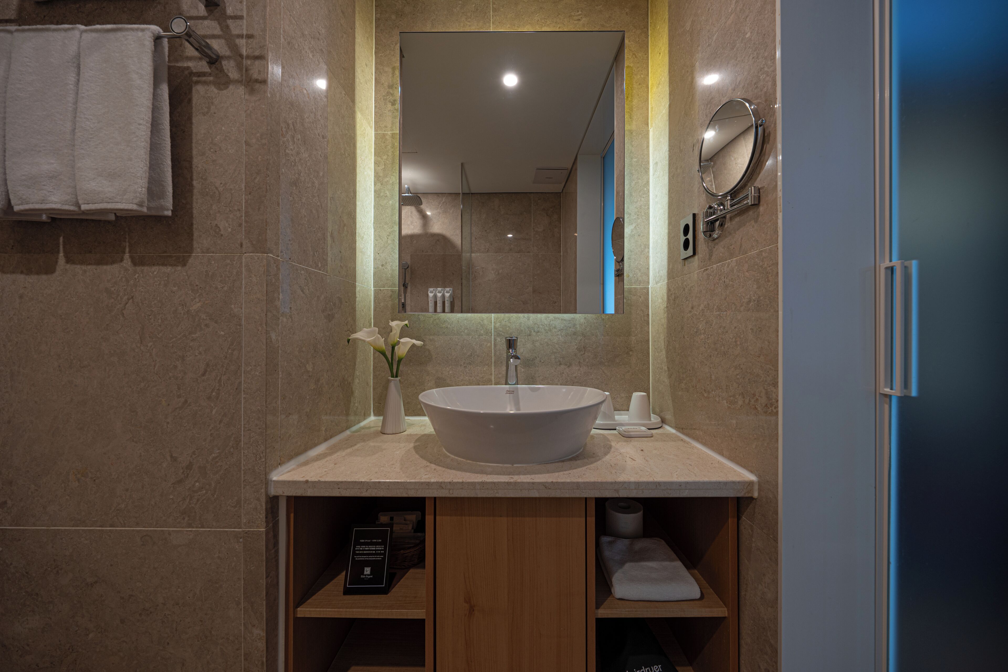 Une salle de bain moderne avec un grand lavabo, un miroir et un porte-serviettes.
