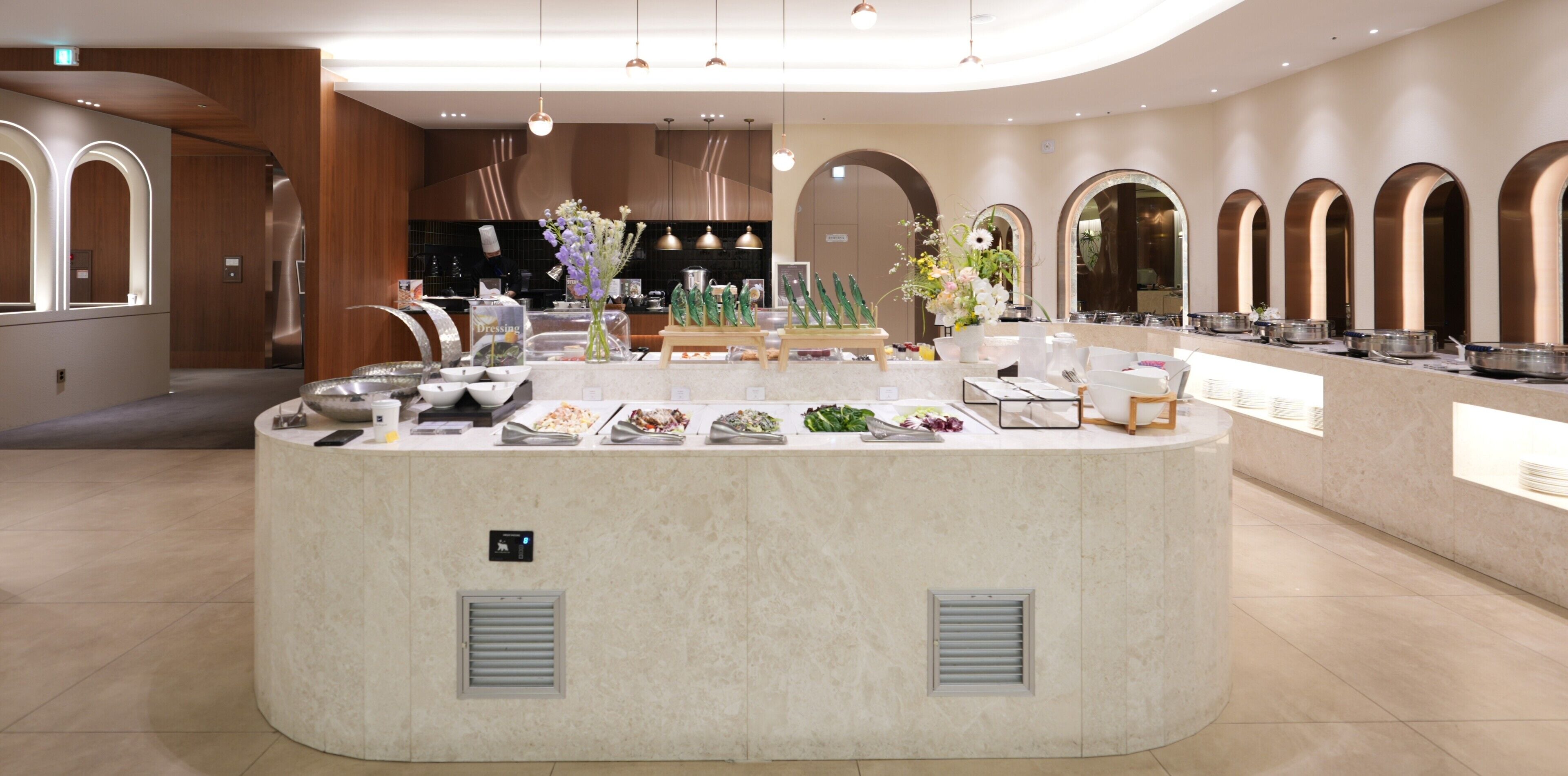 A buffet area with various food stations, a chef's station, and a seating area with tables and chairs.