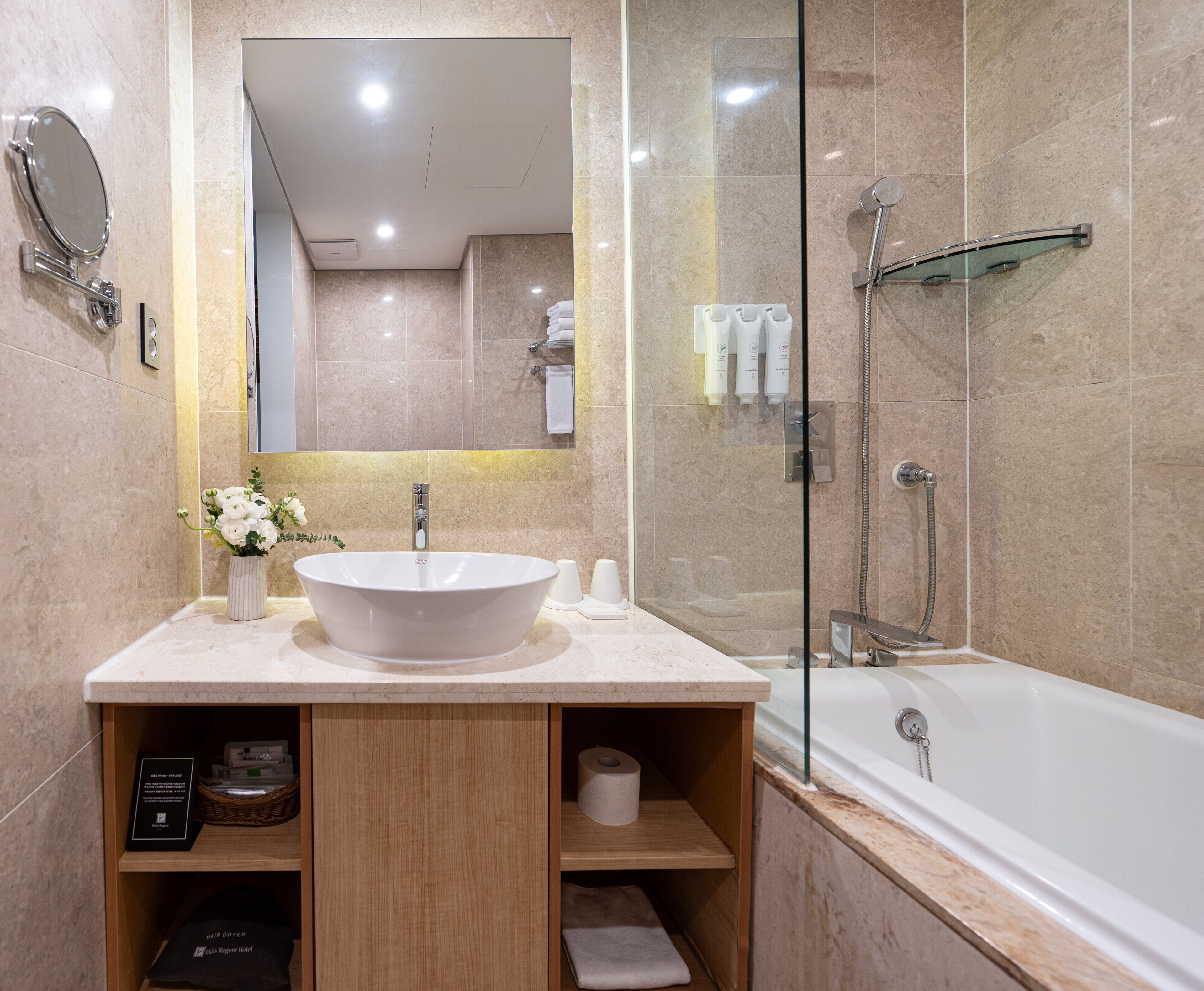 A modern bathroom with a freestanding bathtub, a large mirror, and a vanity with a sink and storage.