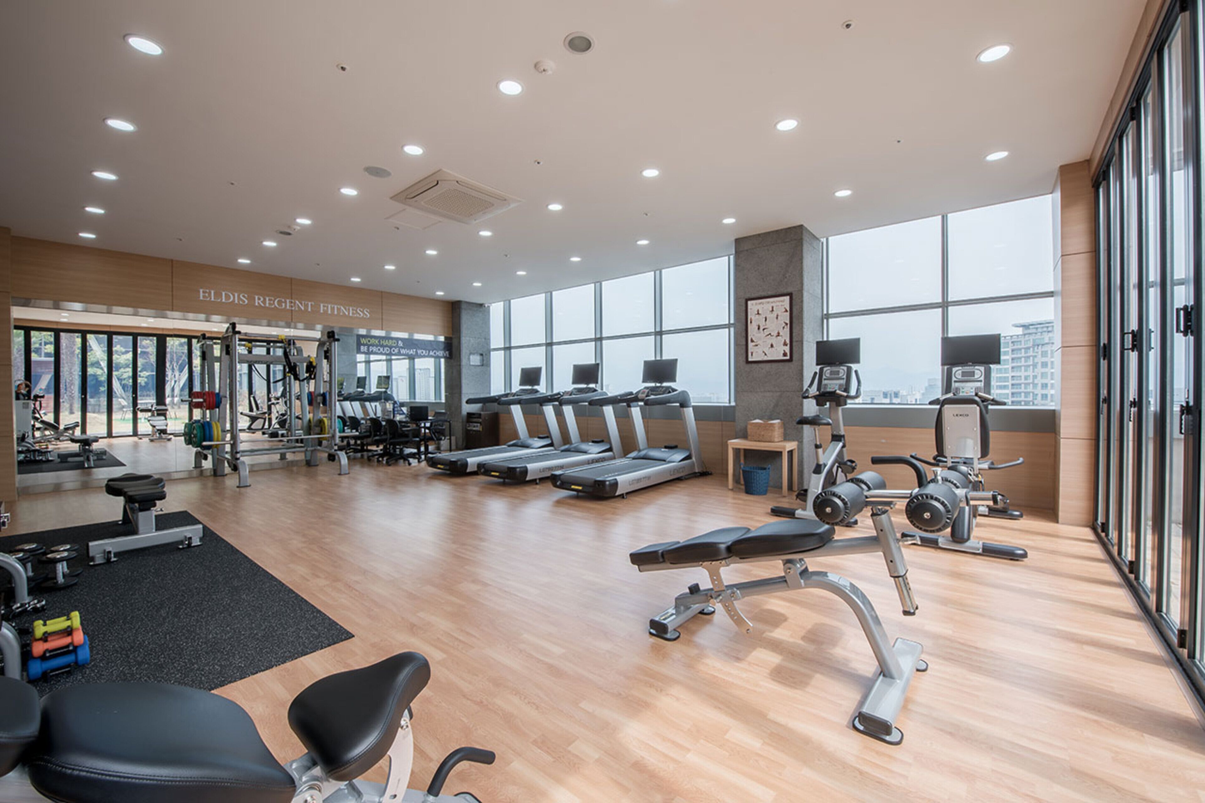 A modern gym with treadmills, weight machines, and free weights.