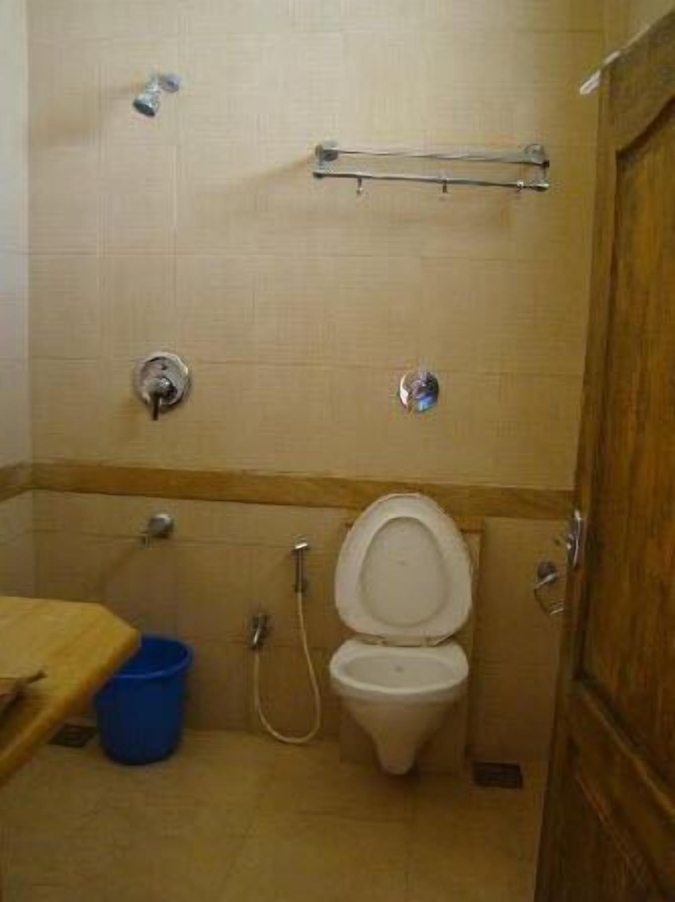 A small bathroom with a toilet, a shower, and a sink.