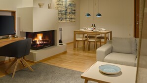 Un salon avec une cheminée, une table à manger avec des chaises, un canapé et un téléviseur.