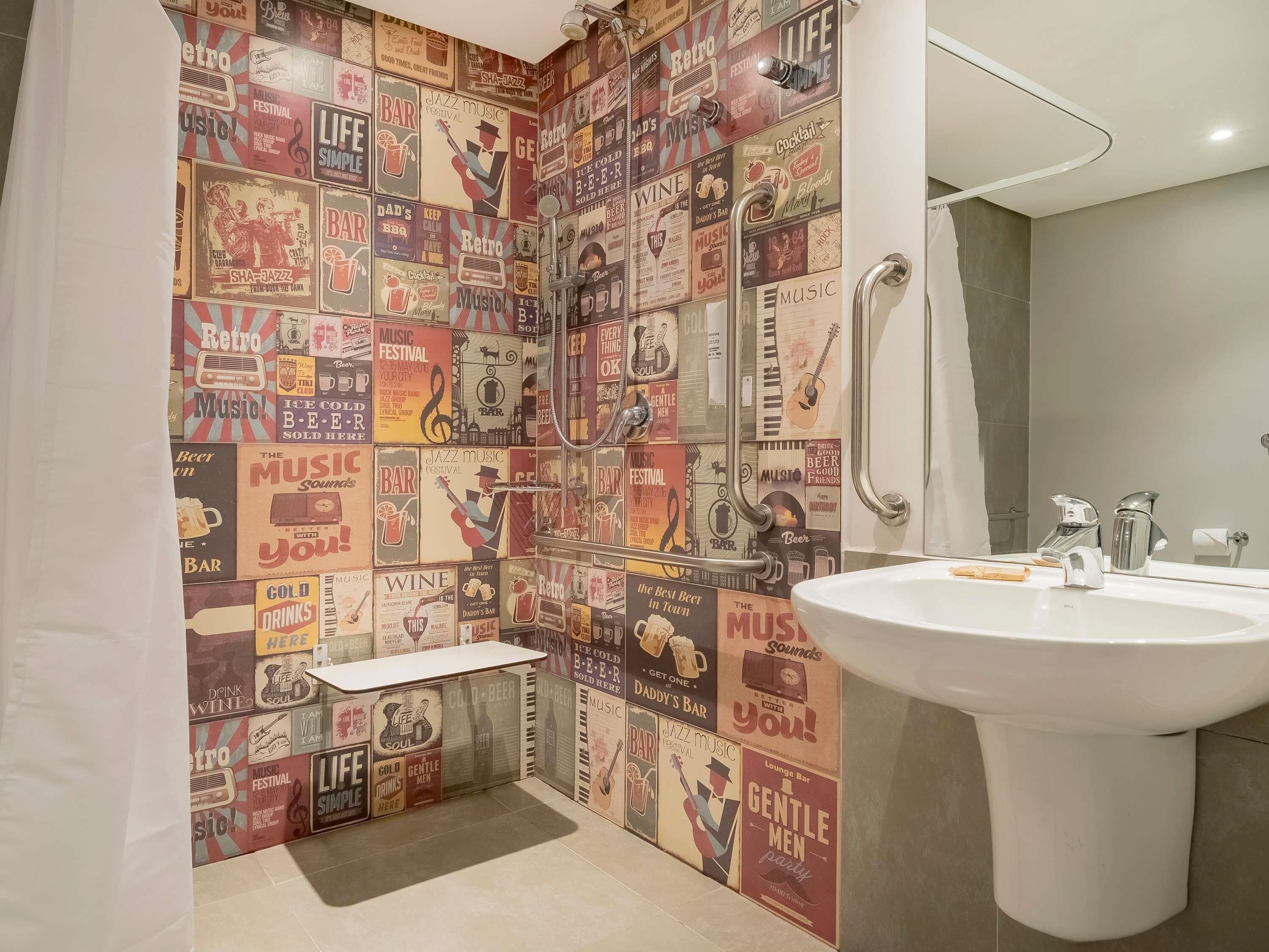 Un baño con una pared de estilo retro, un lavamanos blanco y una zona de ducha.