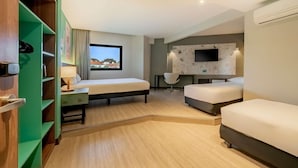 A modern hotel room with a bed, a desk, a chair, a TV, and a window with a view.