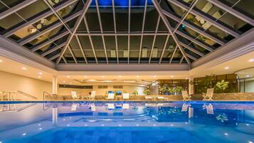 Una piscina techada, sillones reclinables de piscina