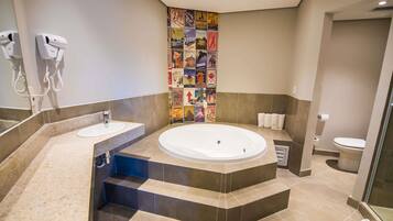 A modern bathroom with a large bathtub, a sink, and a shower area.