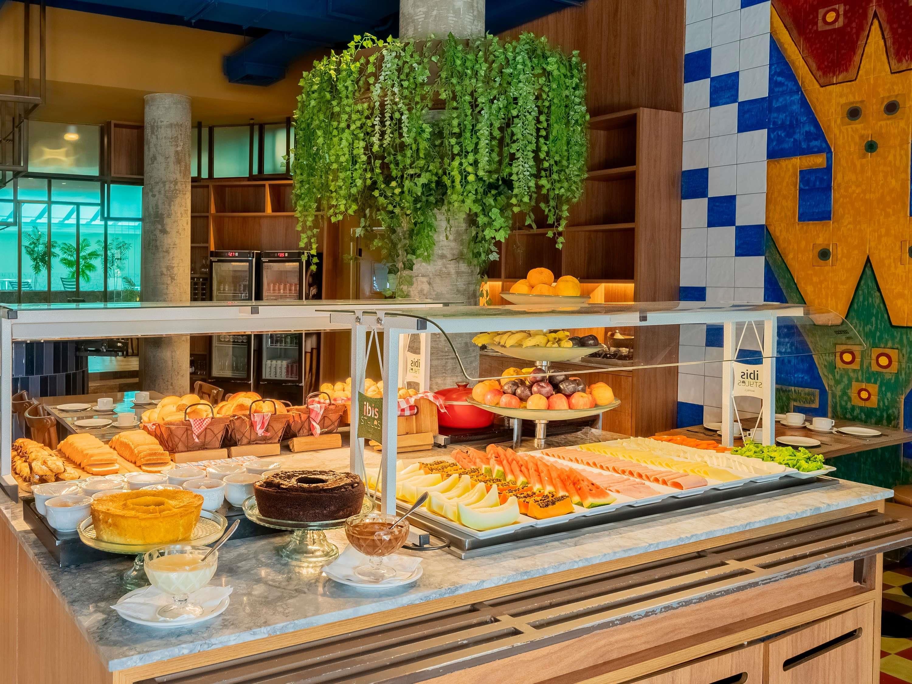 Un bufé con diversas opciones de comida y una planta decorativa.