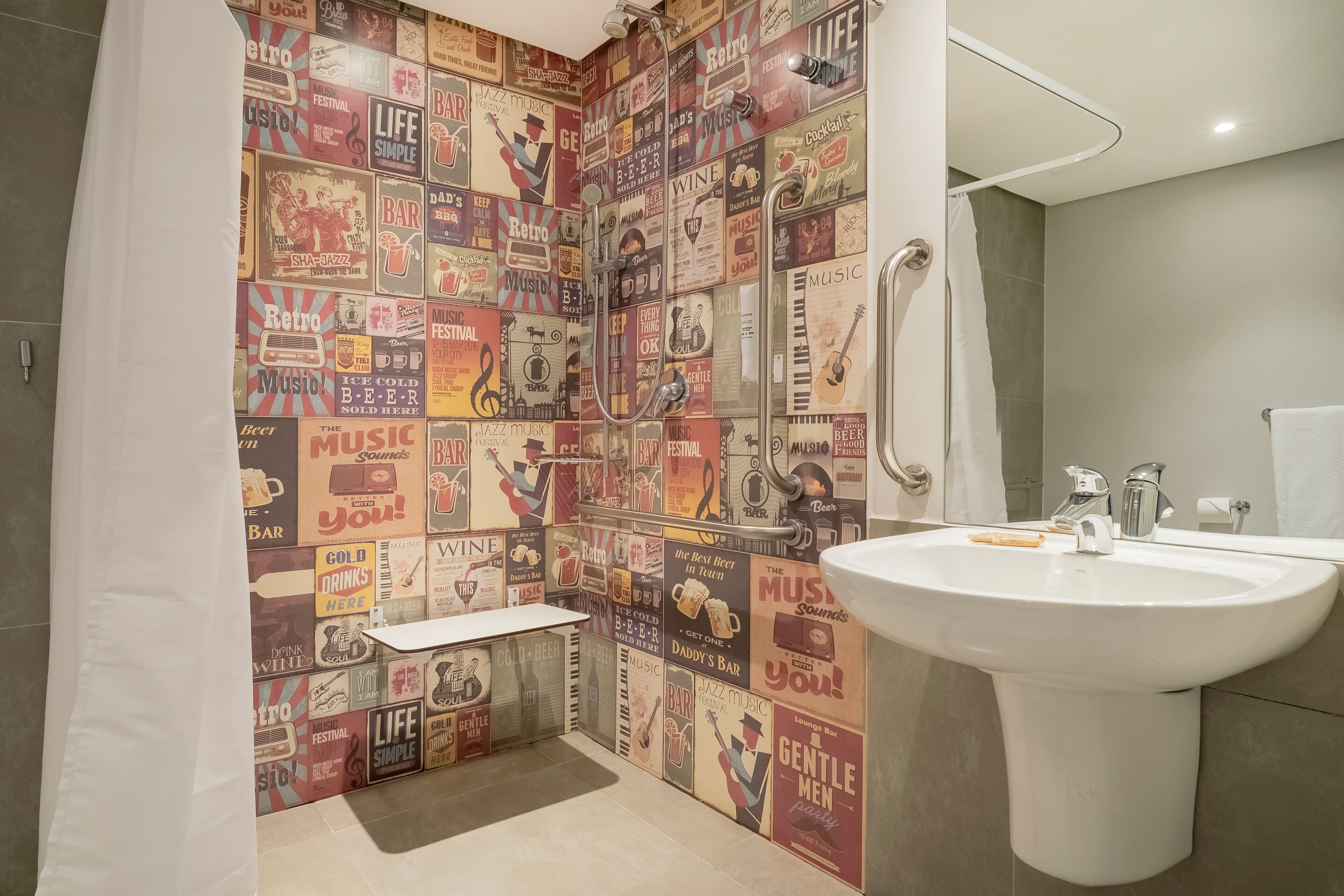 A bathroom with a retro-themed wall, a white sink, and a shower area.