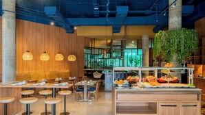A modern restaurant with wooden walls, hanging pendant lights, and a buffet area with various food items. - Ibis Styles Sorocaba Santa Rosalia (Sorocaba)