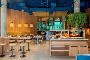 A modern restaurant with wooden walls, hanging pendant lights, and a buffet area with various food items. - Ibis Styles Sorocaba Santa Rosalia (Sorocaba)