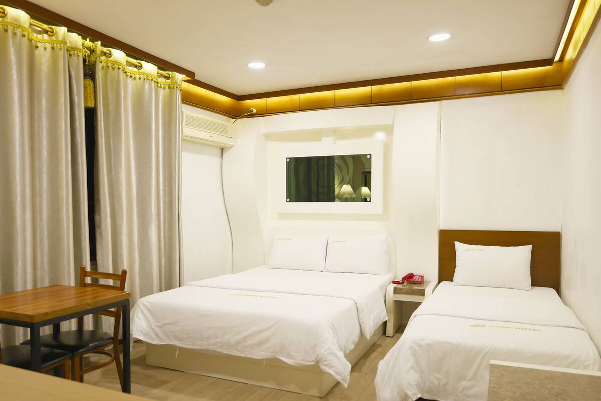 Een hotelkamer met twee bedden, een bureau en een stoel.