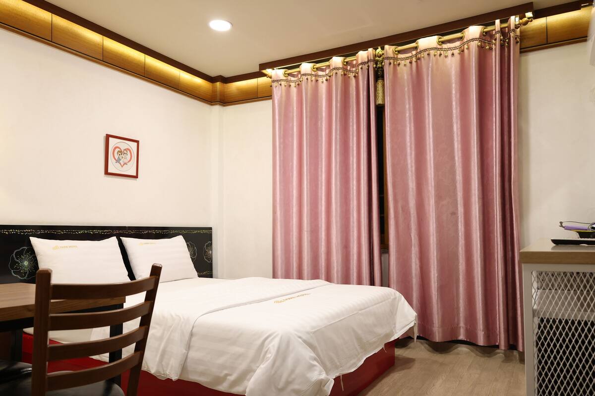 Een hotelkamer met een bed, een bureau en een stoel.