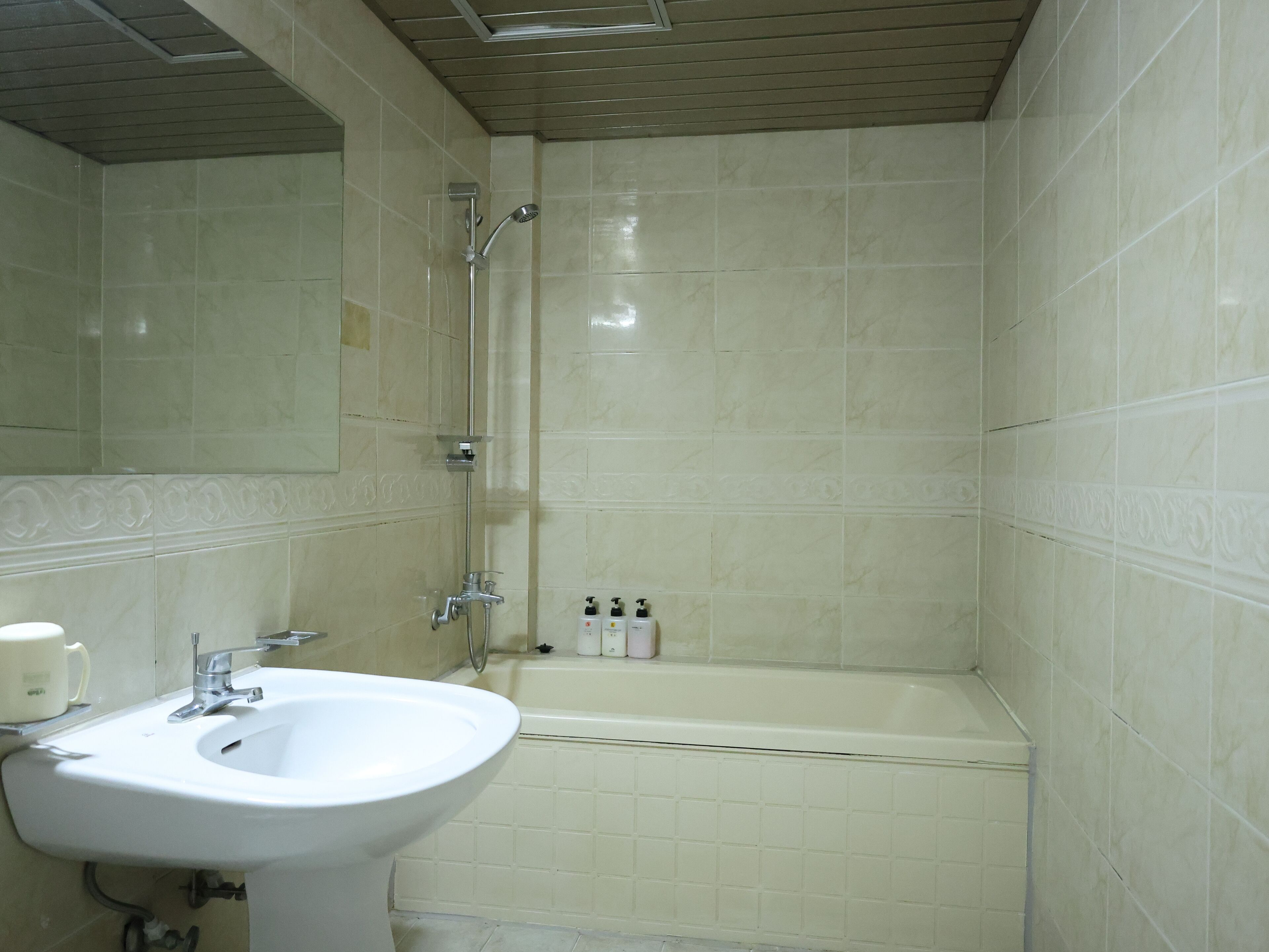 A bathroom with a sink, mirror, shower, and bathtub.