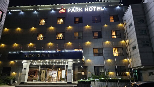 Un hôtel à plusieurs étages, doté d’une enseigne lumineuse indiquant « PARK HOTEL » et « ANDONG PARK HOTEL ».