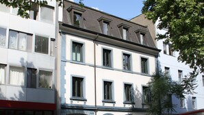 A multi-story building with a white facade and blue window frames. - Apartments Spalenring10 (Basel)