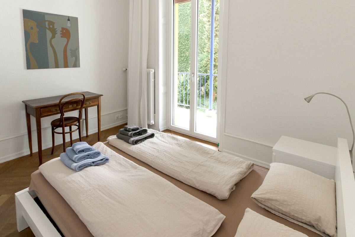 Une chambre avec deux lits, un bureau et une chaise.