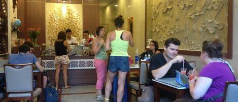 A restaurant interior with a counter, seating area, and decorative wall art.