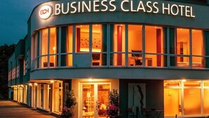 A building with a sign reading "BUSINESS CLASS HOTEL" and multiple windows with warm interior lighting. - Business Class Hotel Ebersberg (Ebersberg)