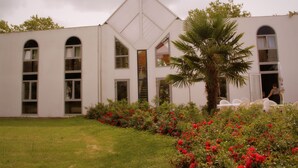 A modern building with arched windows and a central tower. - Agape Hotel (Bessines)