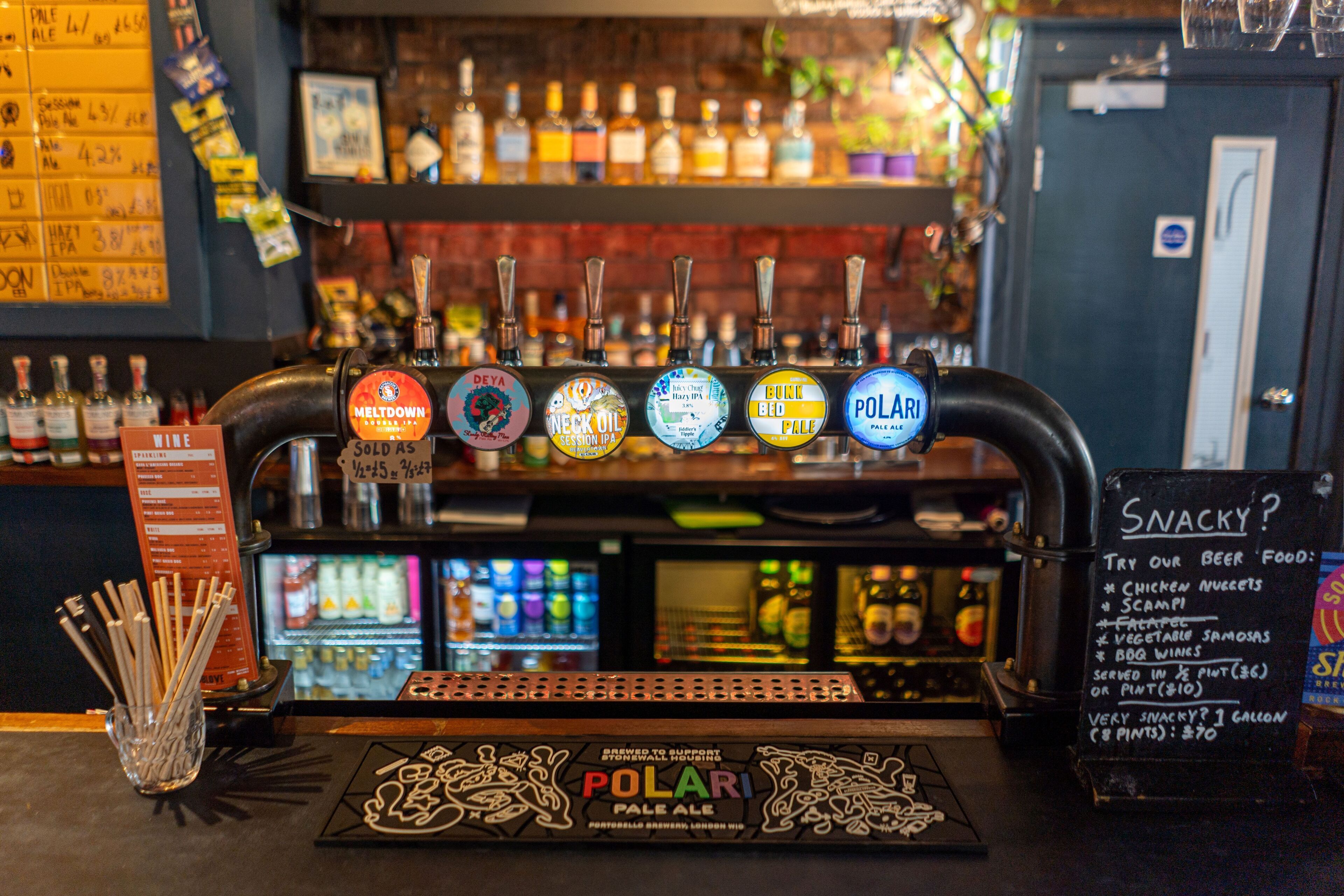 A bar with a beer tap labeled "POLARI Pale Ale" and a menu board listing snacks and beer food.