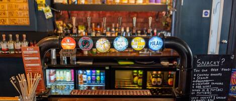 A bar with a beer tap labeled "POLARI Pale Ale" and a menu board listing snacks and beer food.