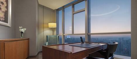 A modern office space with a desk, chair, and a large window offering a city view.