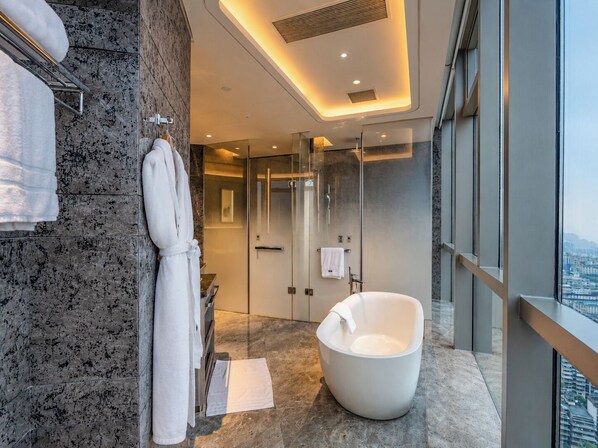 A modern bathroom with a freestanding bathtub, a glass shower enclosure, and a view of the city. - The Westin Changsha (Changsha)