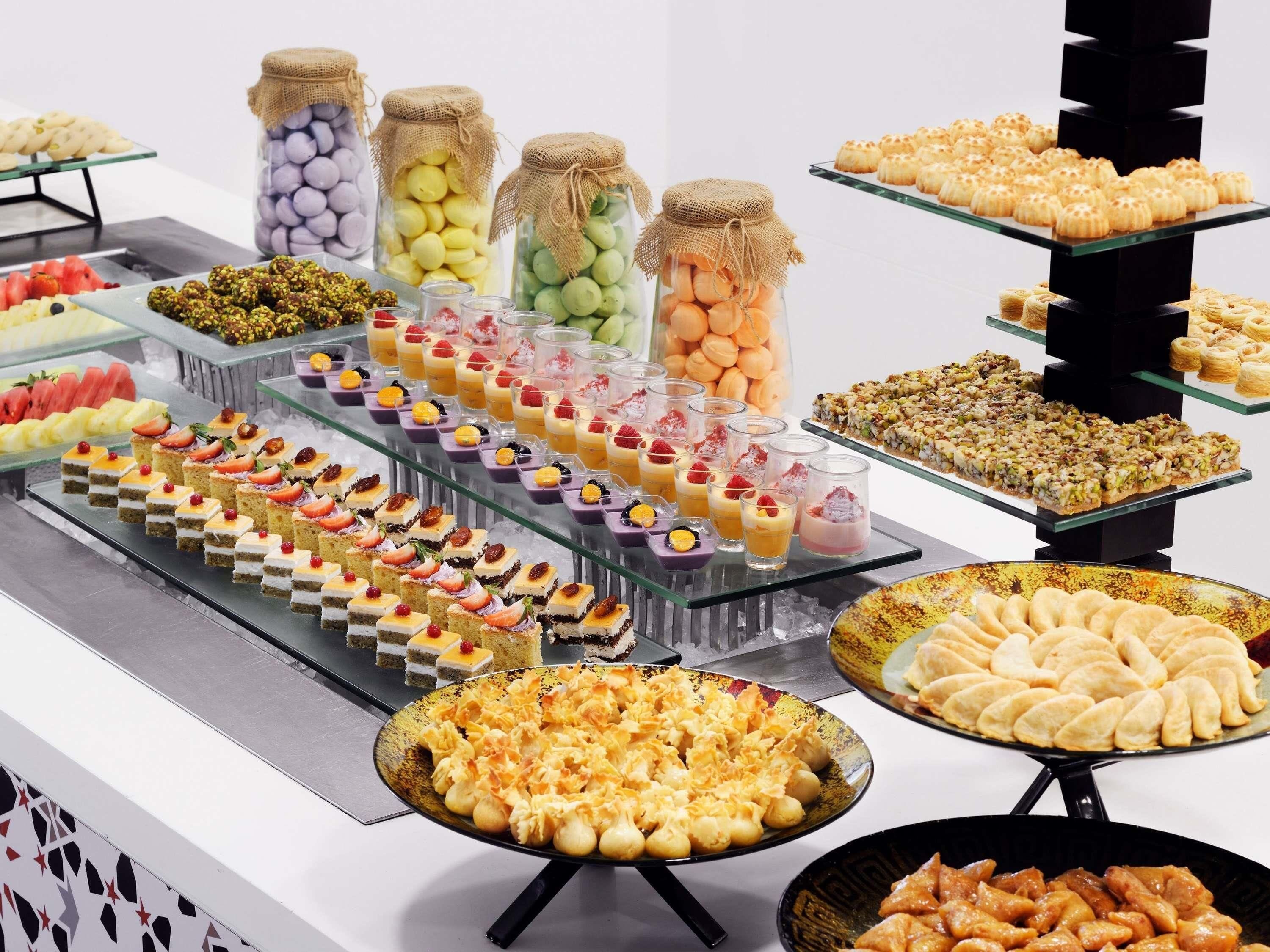 A buffet with various food items including pastries, desserts, and fruits.